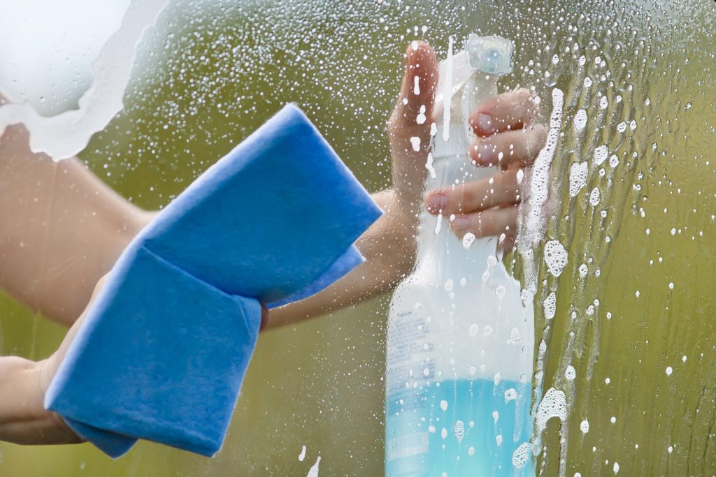 Person cleaning glass with sponge